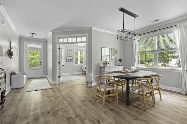 dining area featuring visible vents, crown molding, a healthy amount of sunlight, and an inviting chandelier