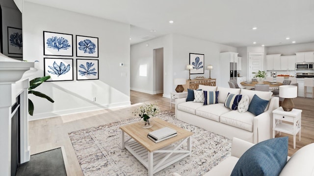 living area with light wood-type flooring, a fireplace, and recessed lighting