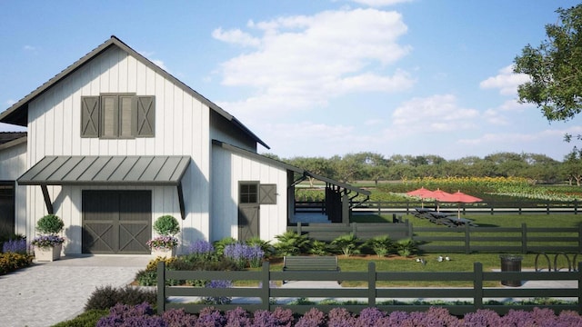 exterior space with metal roof, a standing seam roof, an outdoor structure, a front lawn, and board and batten siding