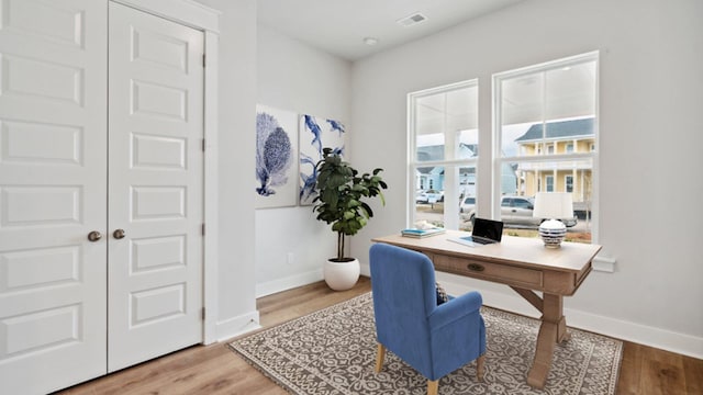 home office with visible vents, baseboards, and wood finished floors