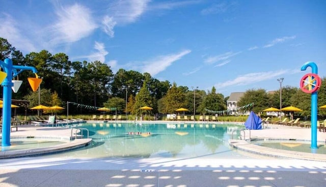 pool with a patio area and a hot tub