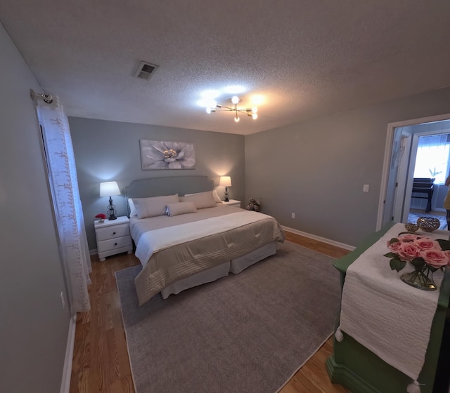 712 Nora Ln, Mount Pleasant, SC 29464 - bedroom featuring wood finished floors, a textured ceiling, and baseboards