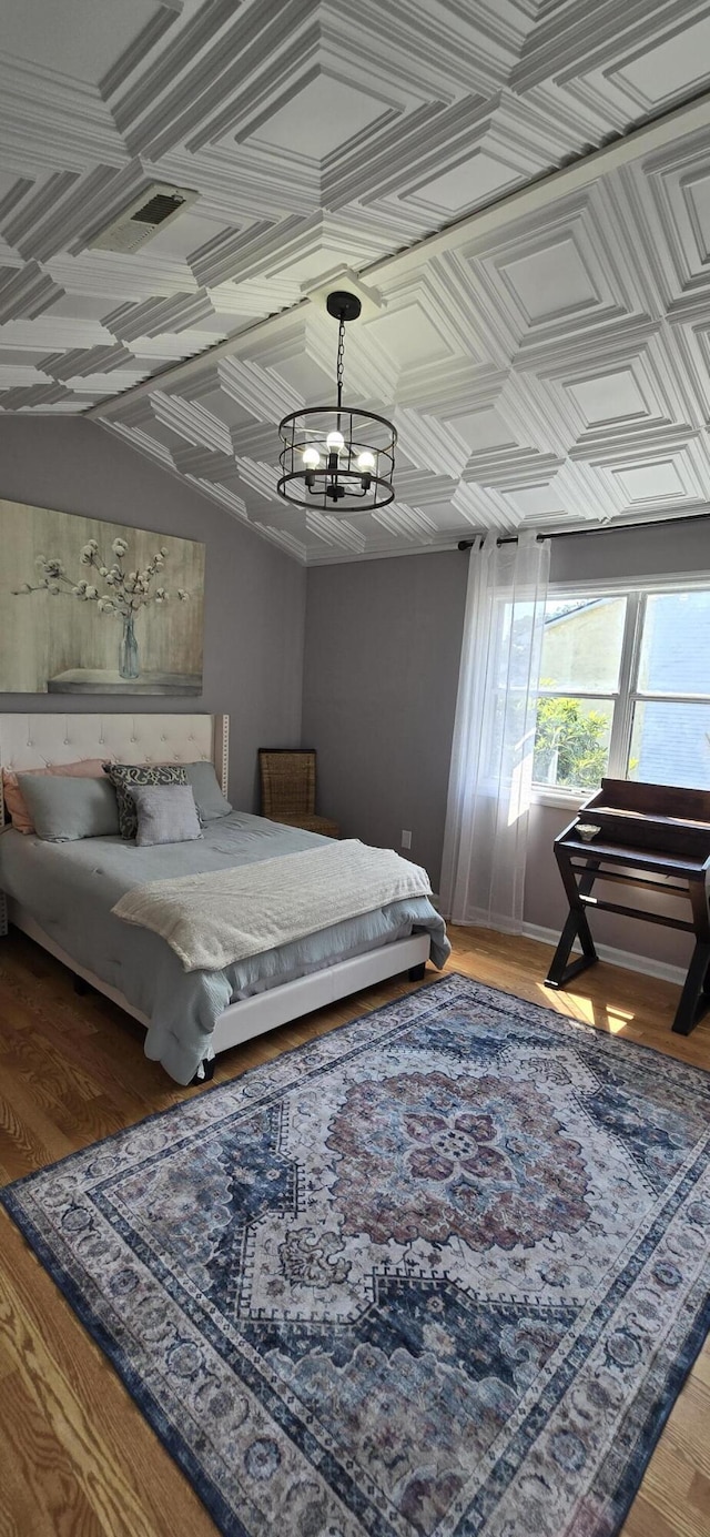 712 Nora Ln, Mount Pleasant, SC 29464 - bedroom with a chandelier, an ornate ceiling, and light wood-style floors