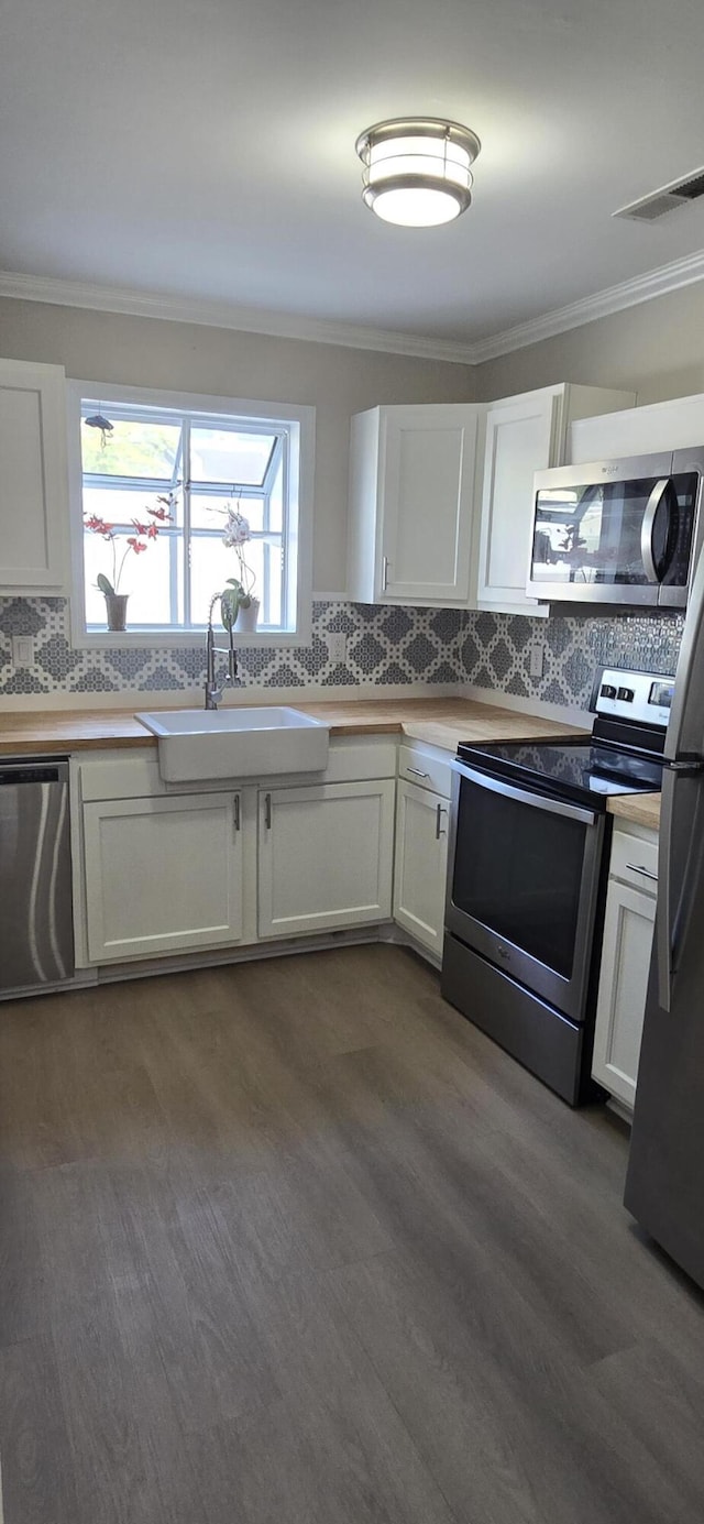 712 Nora Ln, Mount Pleasant, SC 29464 - kitchen featuring appliances with stainless steel finishes, a sink, dark wood-type flooring, tasteful backsplash, and white cabinets