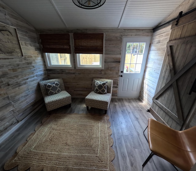 712 Nora Ln, Mount Pleasant, SC 29464 - living area with wooden walls, vaulted ceiling, a barn door, and hardwood / wood-style floors