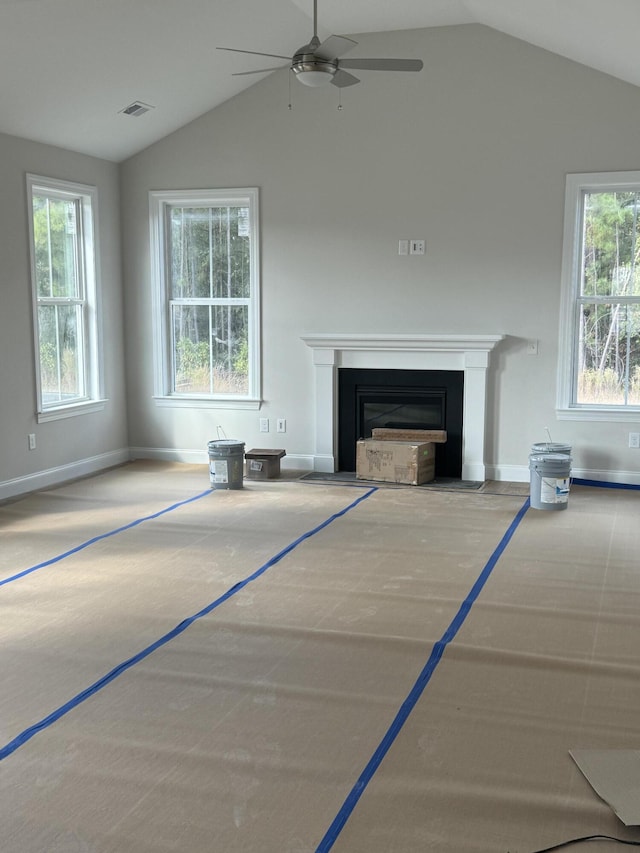 unfurnished living room featuring vaulted ceiling, a fireplace with flush hearth, visible vents, and baseboards