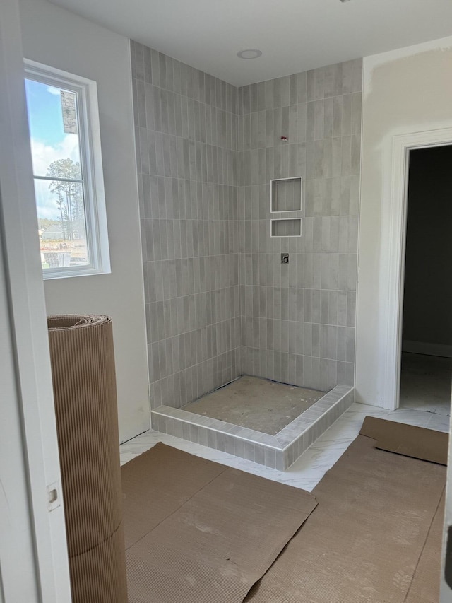 full bathroom featuring tile patterned flooring and a tile shower