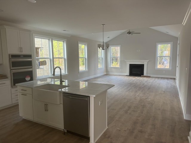 kitchen with white cabinets, a center island with sink, sink, appliances with stainless steel finishes, and light stone counters