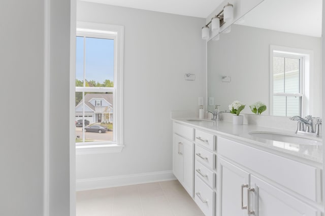 full bathroom featuring double vanity, tile patterned flooring, baseboards, and a sink