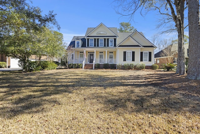 view of front of property featuring a garage, a front yard, and a porch