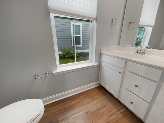 bathroom with hardwood / wood-style floors, vanity, and toilet