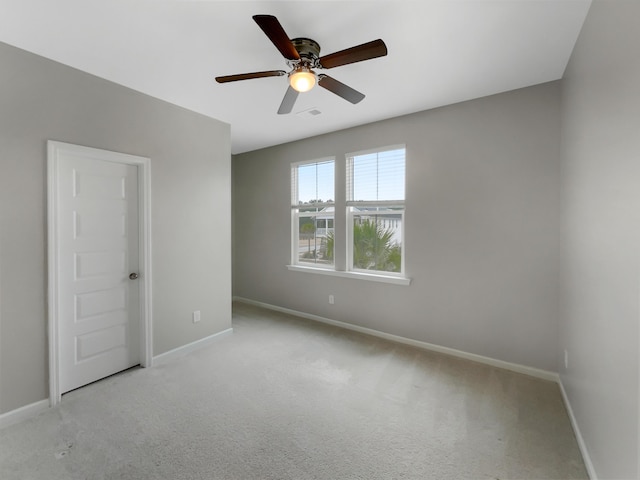 carpeted spare room with ceiling fan