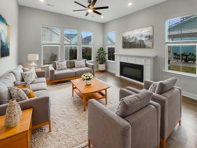 living room with dark hardwood / wood-style flooring and ceiling fan