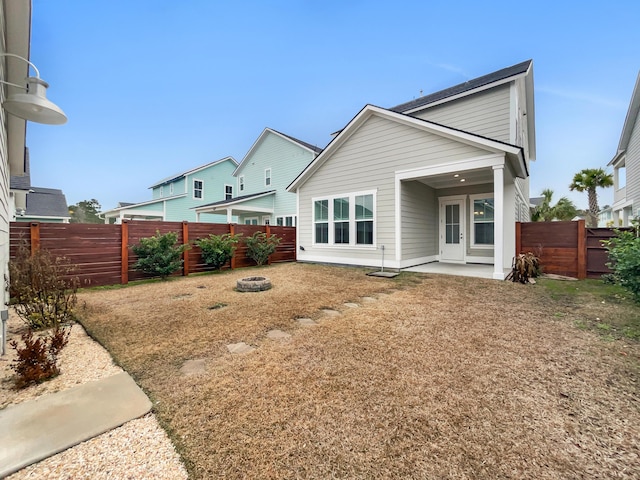 rear view of house with a patio area and an outdoor fire pit