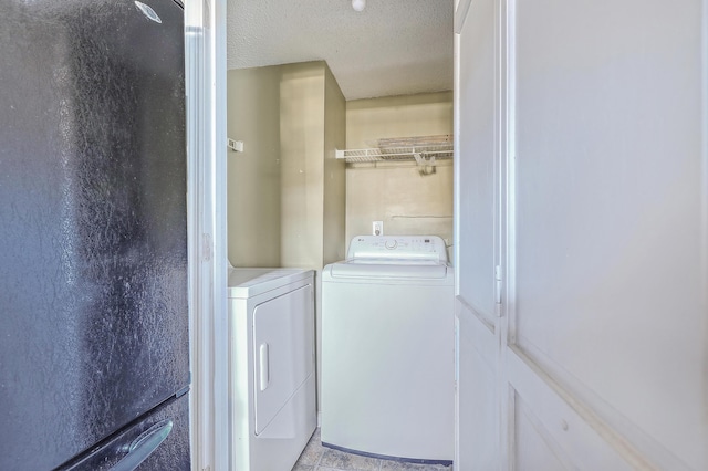 laundry room with washing machine and clothes dryer and a textured ceiling