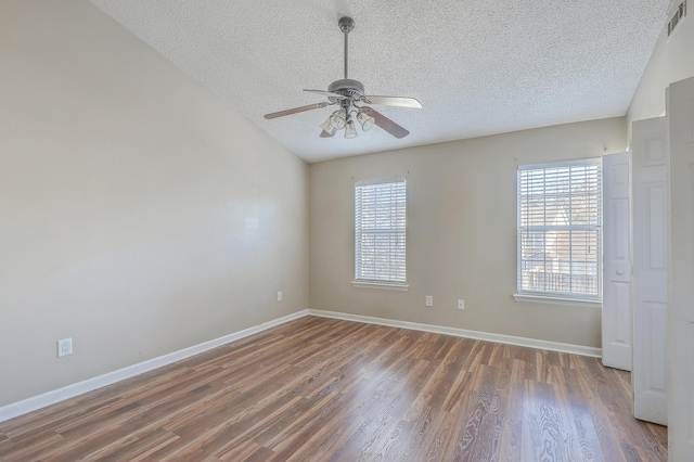 unfurnished room featuring dark hardwood / wood-style flooring, a textured ceiling, plenty of natural light, and ceiling fan