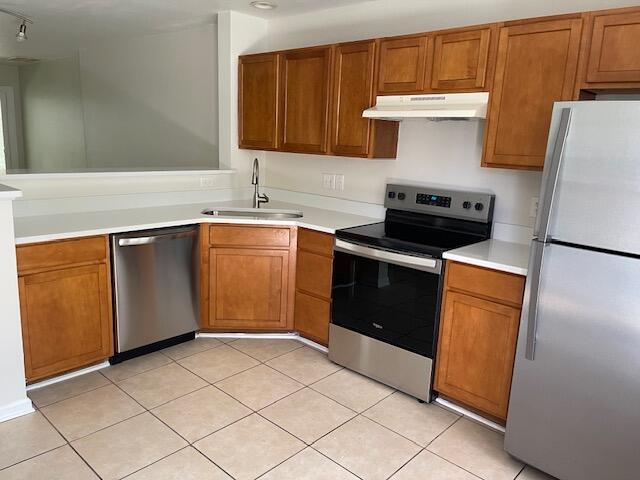 145 Taylor Cir, Goose Creek, SC 29445 - kitchen with appliances with stainless steel finishes, under cabinet range hood, a sink, and brown cabinets