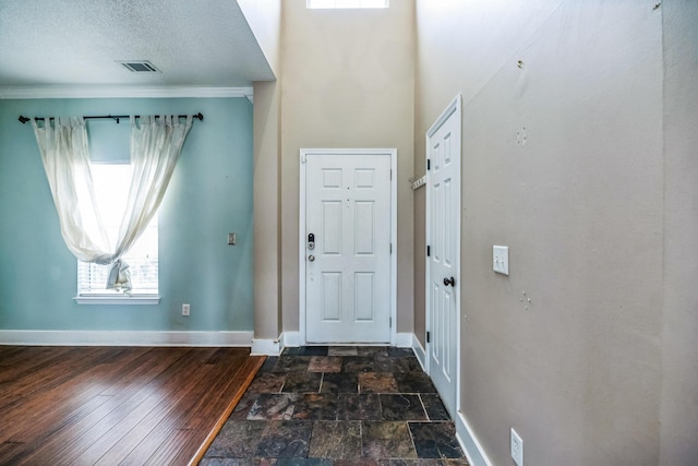 entryway with baseboards, a textured ceiling, visible vents, and dark wood-style flooring