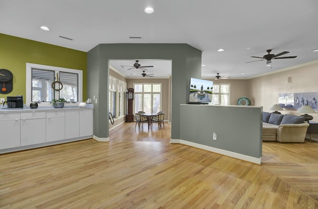 kitchen featuring open floor plan, light wood finished floors, white cabinetry, and a healthy amount of sunlight