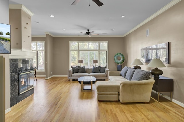 living area with baseboards, a tile fireplace, ornamental molding, light wood-type flooring, and recessed lighting