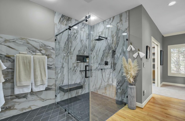 bathroom with a marble finish shower, baseboards, wood finished floors, and ornamental molding