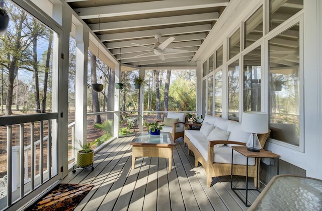 sunroom with ceiling fan and beam ceiling