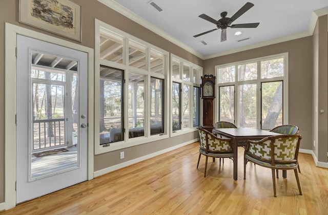 dining area featuring light wood finished floors and ornamental molding