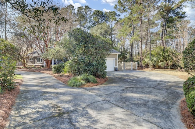 view of front of house with concrete driveway, an attached garage, and fence