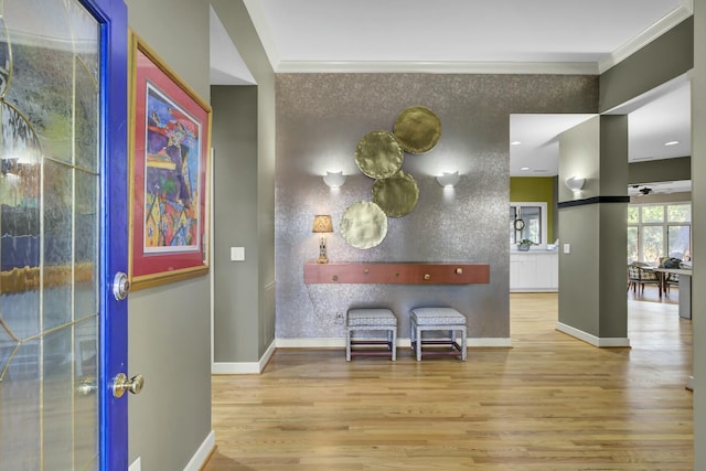 interior space with baseboards, wood finished floors, and crown molding