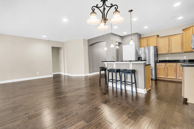 kitchen featuring appliances with stainless steel finishes, decorative light fixtures, dark hardwood / wood-style flooring, and a notable chandelier