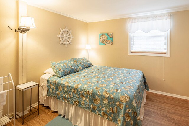 bedroom featuring hardwood / wood-style floors and ornamental molding