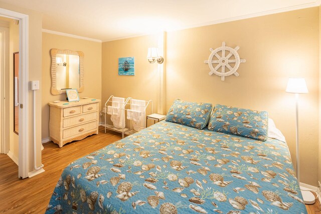 bedroom with wood-type flooring and ornamental molding