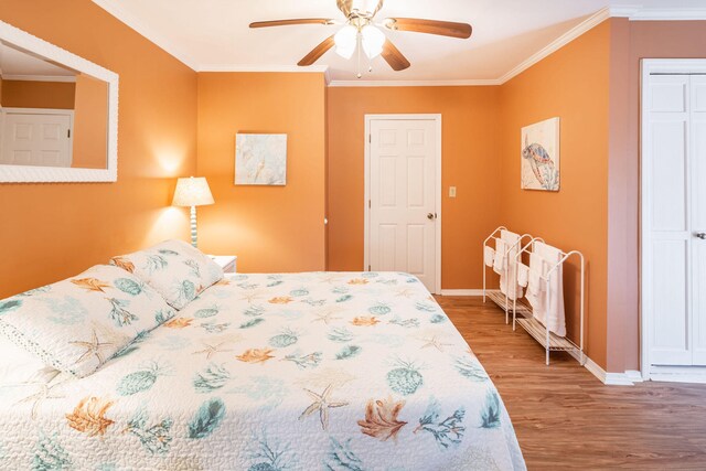 bedroom with ceiling fan, ornamental molding, and hardwood / wood-style flooring