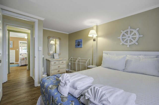 bedroom featuring crown molding and dark hardwood / wood-style floors