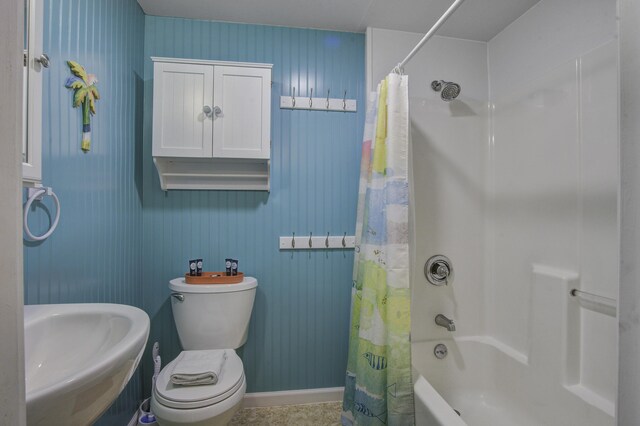 full bathroom featuring toilet, shower / tub combo with curtain, and sink