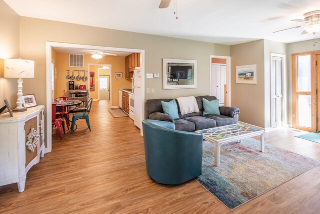 living room featuring ceiling fan and light hardwood / wood-style floors