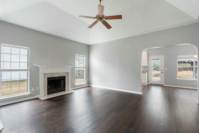 unfurnished living room with lofted ceiling, ceiling fan, and dark hardwood / wood-style flooring