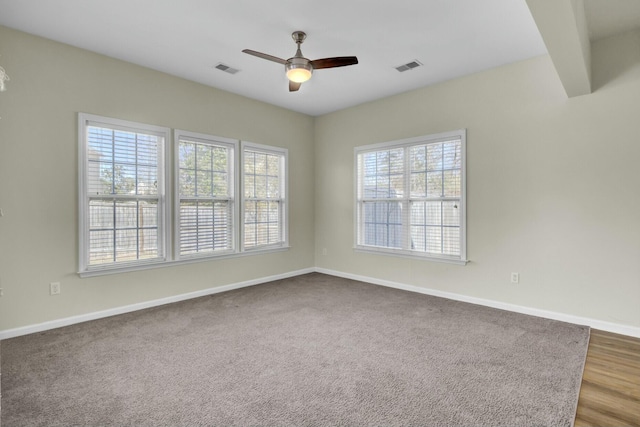 spare room featuring a ceiling fan, visible vents, and baseboards