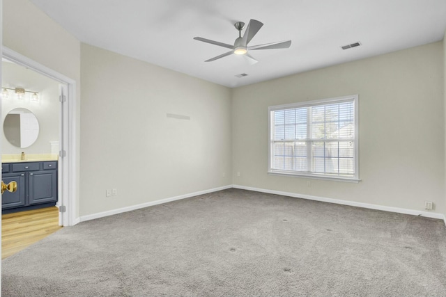 empty room with light colored carpet, visible vents, and baseboards