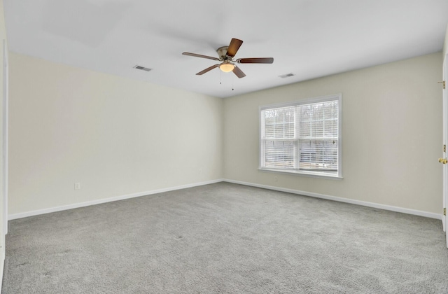 empty room with carpet, visible vents, and baseboards