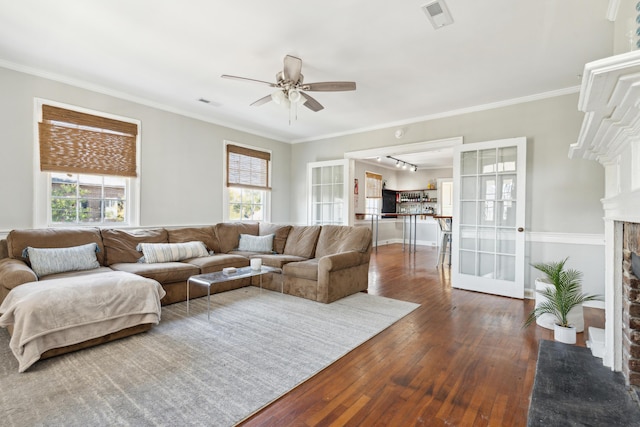 living room with ceiling fan, ornamental molding, dark hardwood / wood-style flooring, and a wealth of natural light