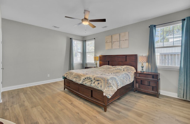 bedroom with light hardwood / wood-style flooring, multiple windows, and ceiling fan