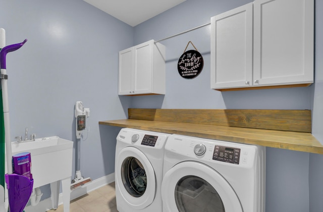 washroom with sink, washing machine and dryer, and cabinets