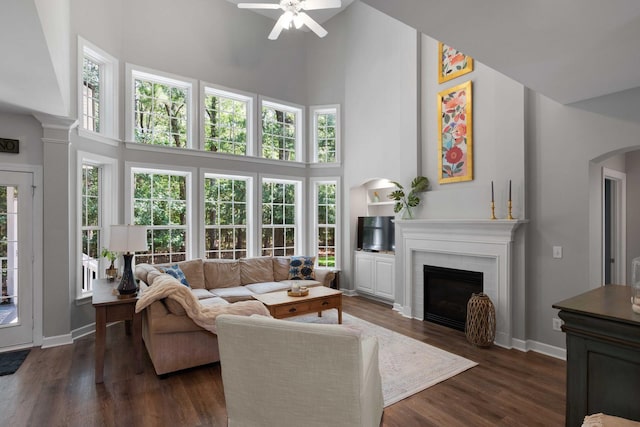 3574 Toomer Kiln Cir, Mount Pleasant, SC 29466 - living room with a high ceiling, a ceiling fan, a brick fireplace, dark wood-style floors, and arched walkways