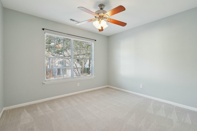 unfurnished room with light carpet, visible vents, baseboards, and ceiling fan