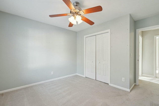 unfurnished bedroom with light carpet, ceiling fan, baseboards, and a closet