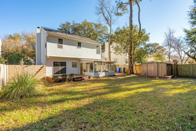 back of house featuring a lawn, a chimney, a fenced backyard, and a sunroom