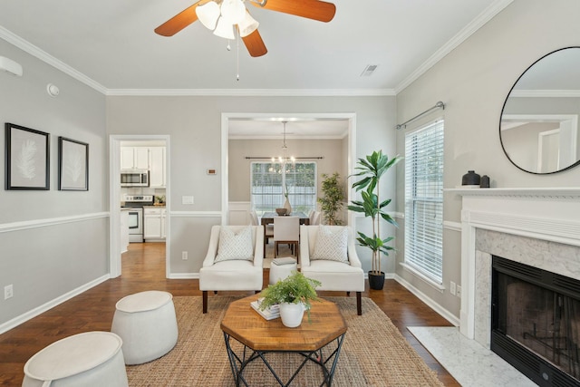 sitting room with a fireplace, wood finished floors, visible vents, baseboards, and ornamental molding