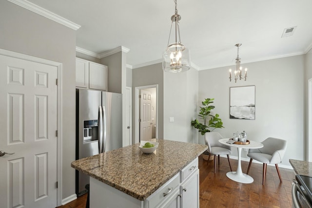 kitchen featuring dark wood-style flooring, white cabinets, hanging light fixtures, appliances with stainless steel finishes, and a center island