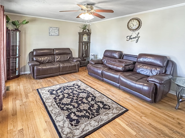 living room with crown molding, wood-type flooring, and ceiling fan